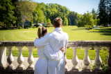 Un couple de dos en peignoir admirent le parc thermal.